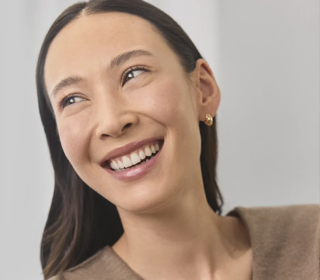 Dark-haired patient Rebecca smiling radiantly