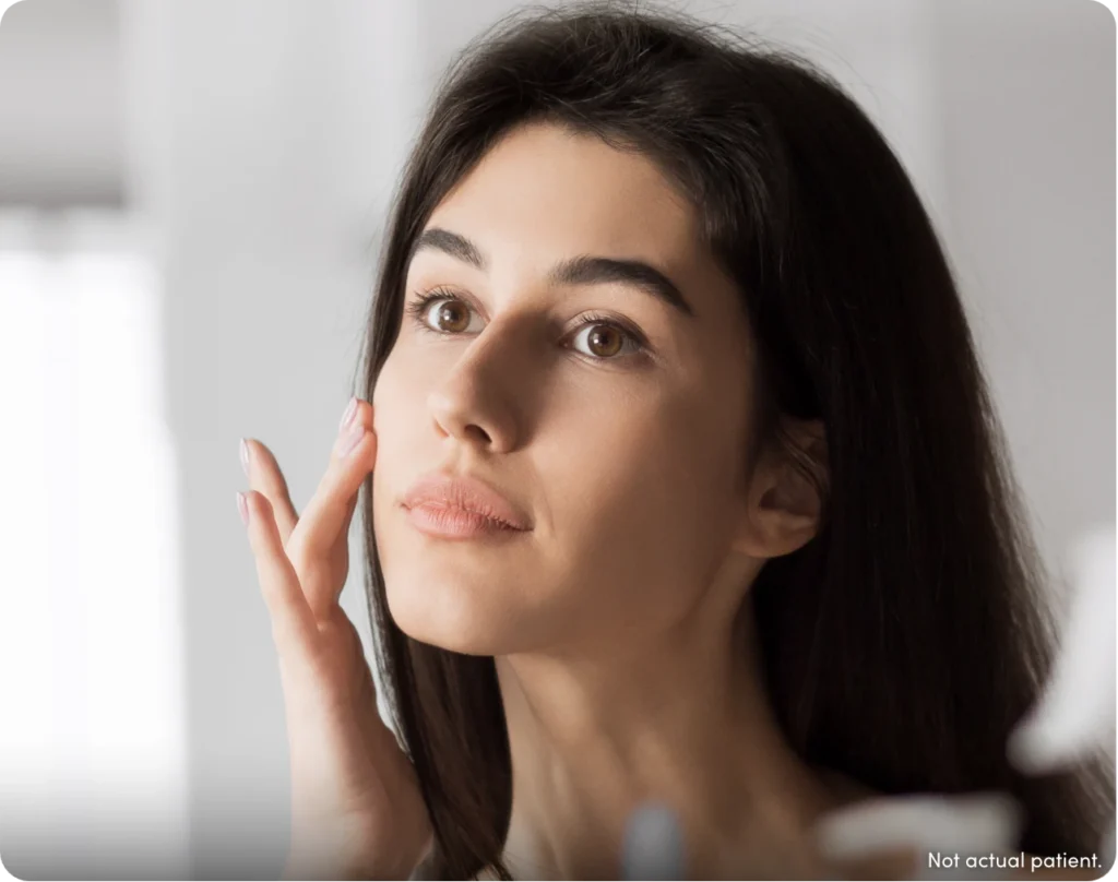 Woman touching her face with "not actual patient".