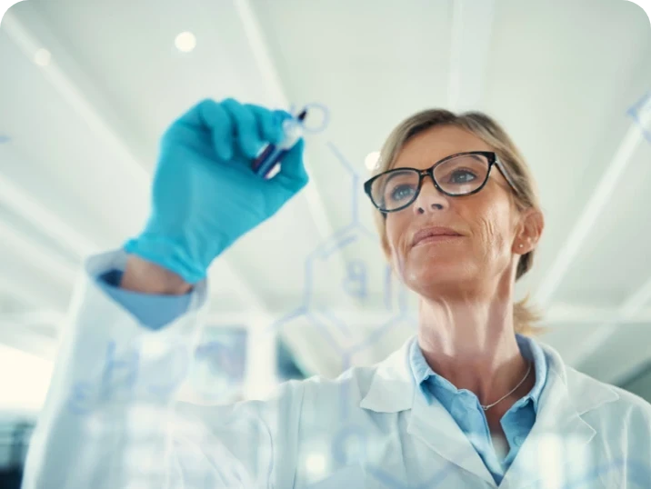 woman scientist writing on a glass board
