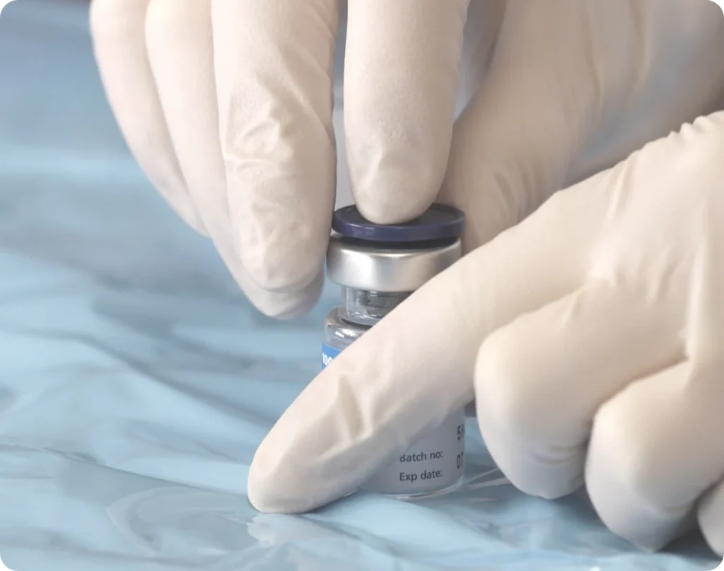 Gloved hands with a vial of Xeomin