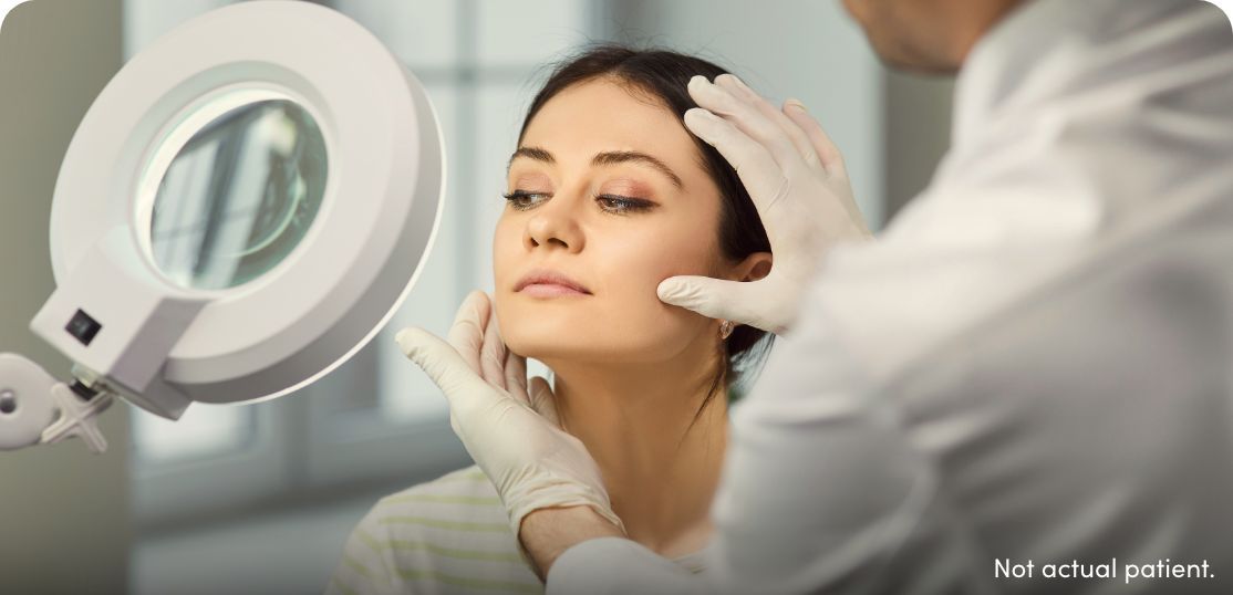 Woman with light on her face consulting with injector.